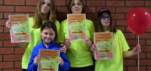 Na zdjęciu stoją cztery dziewczynki ( jedna w niebieskiej bluzie, trzy stojące za nią w zielonych koszulkach. wszystkie trzymają w rękach dyplomy , jedna z nich trzyma również czerwonego balona