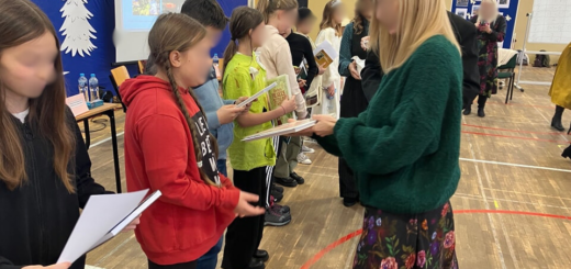 Na zdjęciu kobieta wręcza laureatom  dyplomy i nagrody za zajęcie czołowych miejsc w konkursie.