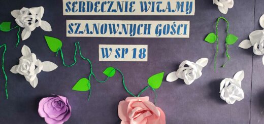 Na szarym tle niebieski napis  napis - Serdecznie witamy w szanownych gości w SP 18, wokół napisu znajdują się przyczepione kolorowe kwiaty.