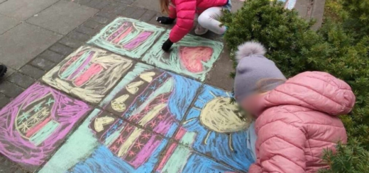 Dzieci rysują na chodniku kolorową kredą kolorowe skarpetki. 