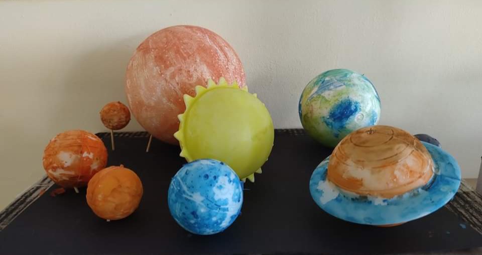 Na zdjęciu leżą wykonane różnokolorowe modele planet i Słońca wykonane przez dzieci .