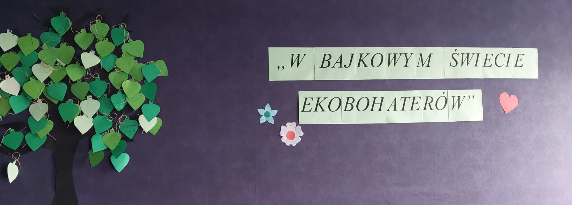 Zdjęcie przedstawia papierowe zielone drzewo z czarnym pniem i napis - W bajkowym świecie ekobohaterów
