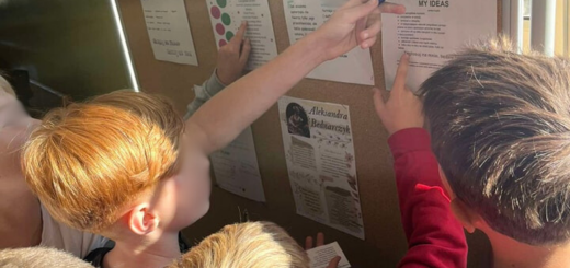 Uczniowie stoją przed tablicą , czytają informacje o kandydatach do Samorządu Uczniowskiego