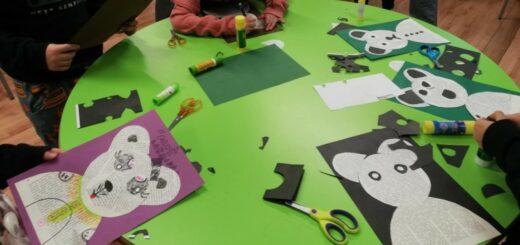 Na zielonym stole leżą prace plastyczne dzieci - misie wycięte z pożółkłych starych zniszczonych książek.